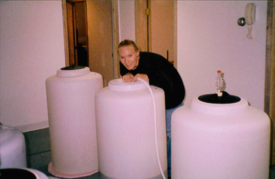 Winemaker Sandi posing with Prairie Berry Winery's first commercial fermentation tanks in Mobridge, South Dakota